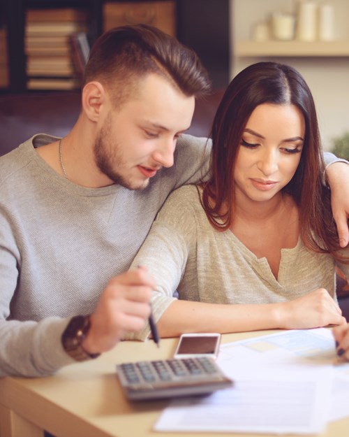 Young couple calculating expenses at home