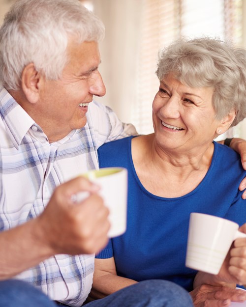 Elderly couple drinking coffee at home