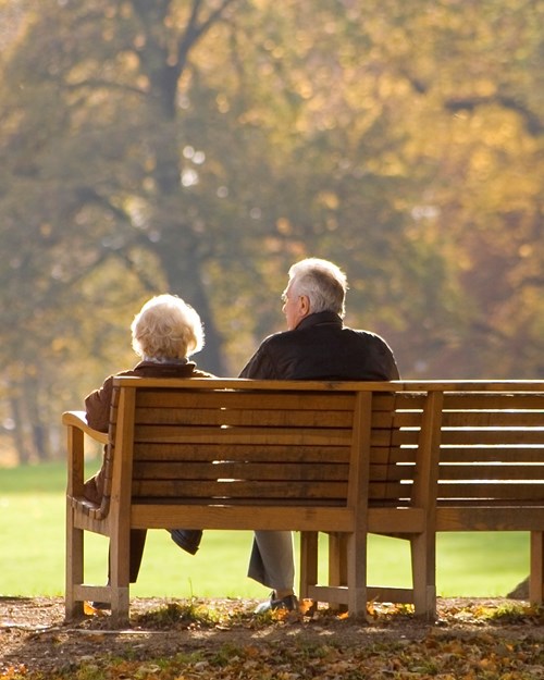 Older couple sat on park bench