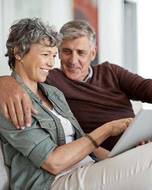 Retired couple looking at mortgages on sofa 