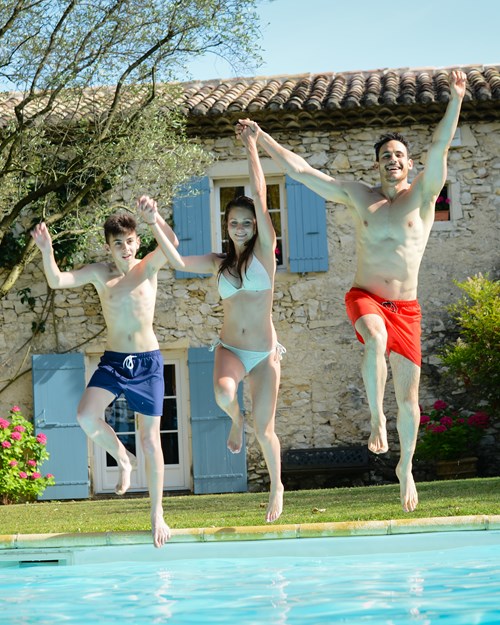 family jumping in a swimming pool