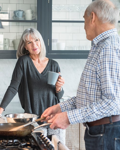 Retired couple cooking together at home